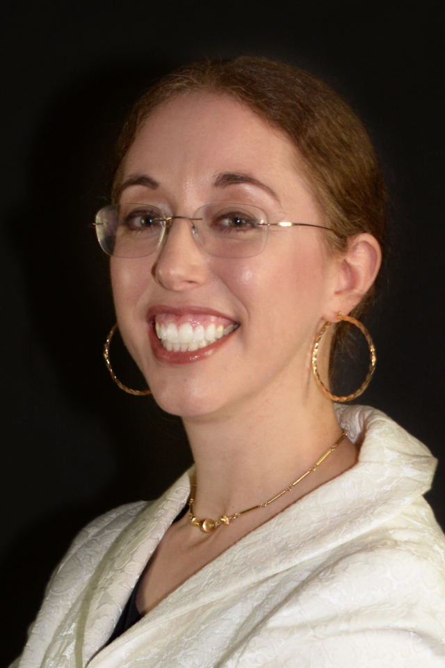 Chief Financial Officer Jaime Campbell in rimless glasses wearing golden hoops and cream colored top smiling