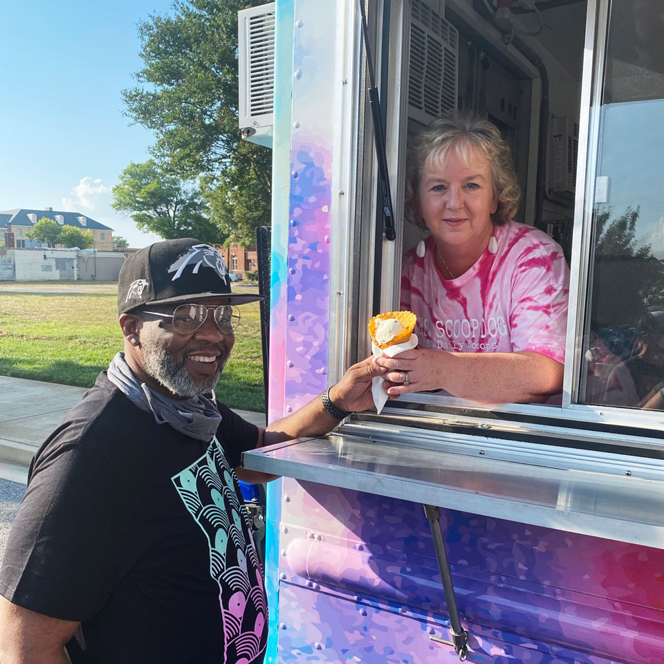 CEO Samantha Kriegshauser hands customer an ice cream from the Daily SCOOPS ice cream truck