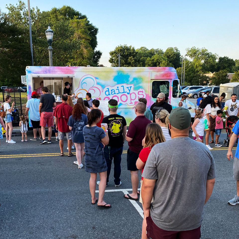 Long line of people formed in front of Daily SCOOPS ice cream truck